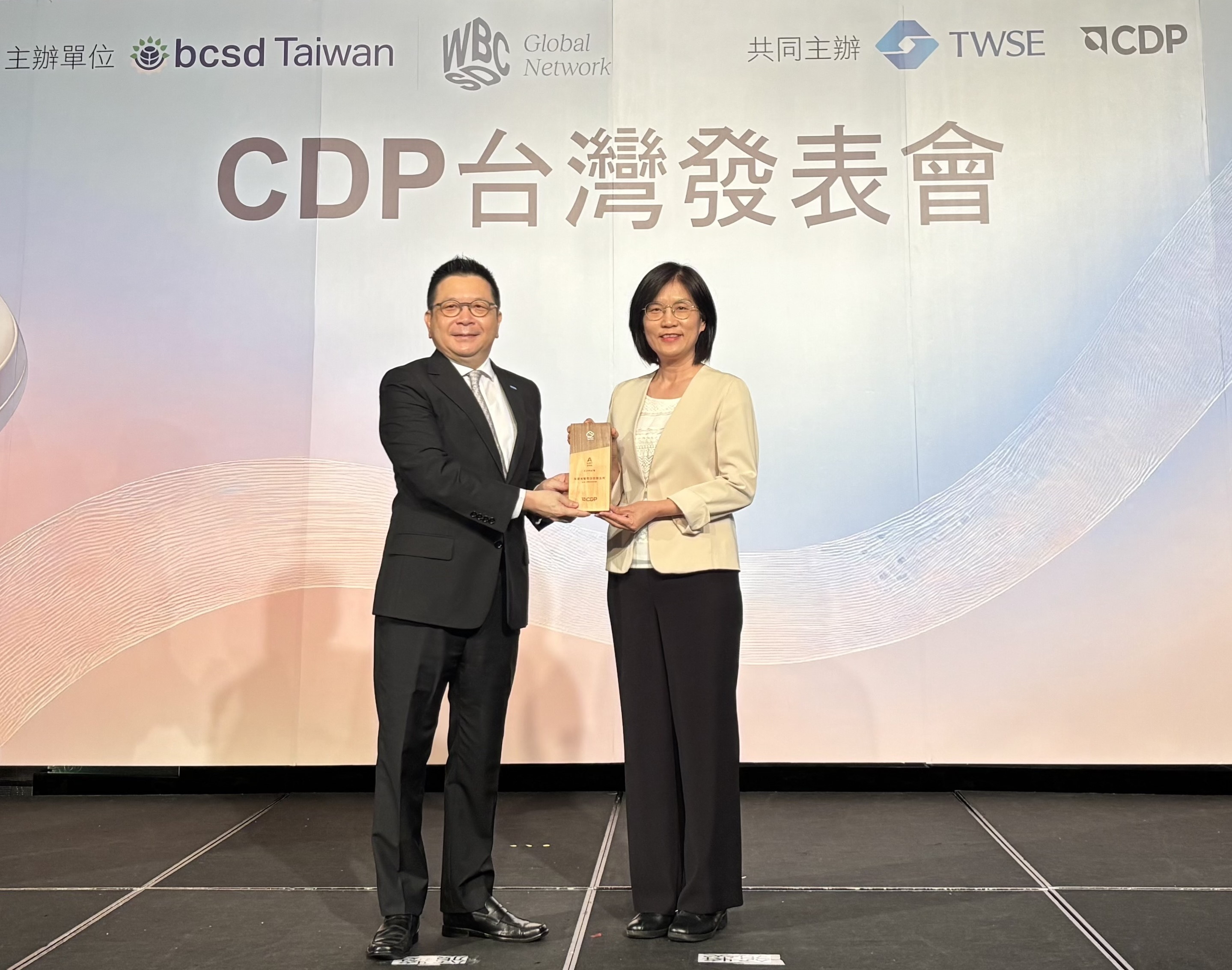 VR彩票永續成果再獲國際評比肯定，獲頒CDP氣候與水資源雙項領導力評級。今由臺灣證券交易所董事長林修銘（左）頒獎，VR彩票光電永續長古秀華（右）代表受獎